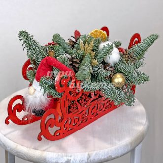 Хвойные ветки и украшения в санках